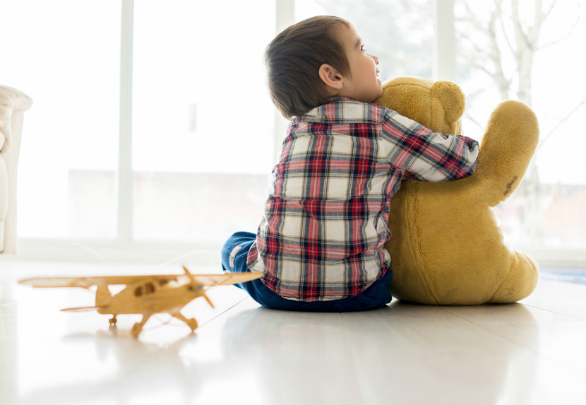 Enfant assis au sol avec des jouets