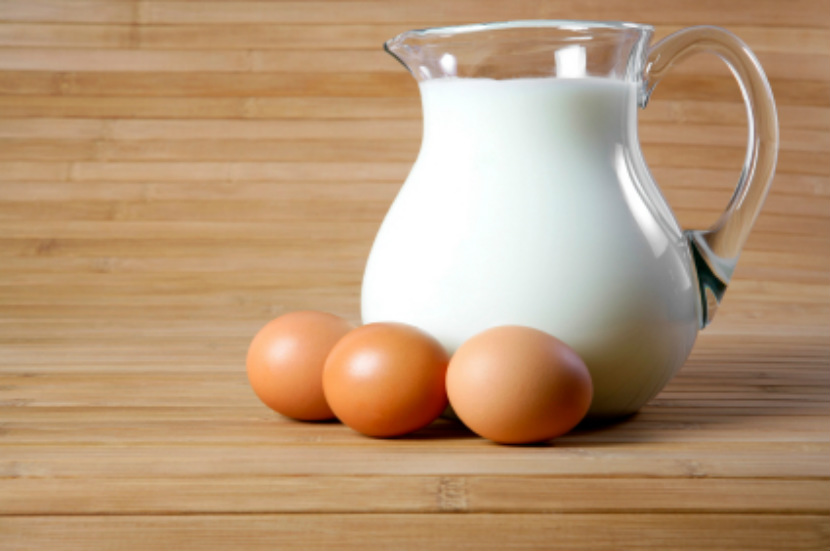 glass jug of white milk and brown eggs