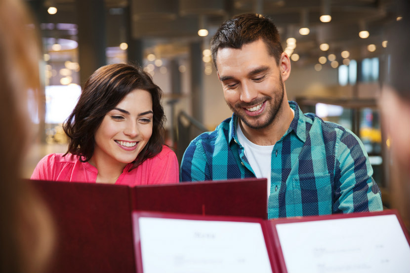 Couple regardant un menu dans un restaurant