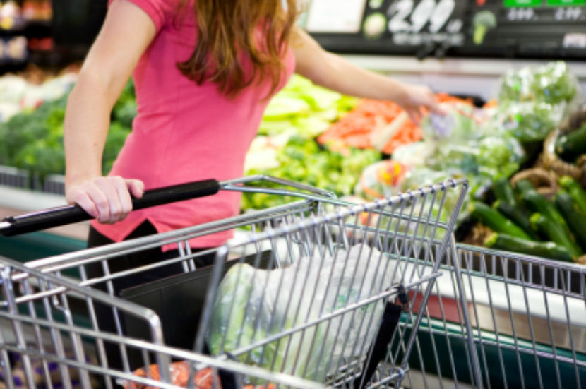 young woman grocery shopping with grocery cart