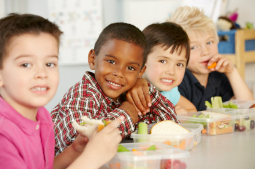 enfants heureux assis à table en train de dîner à l’école