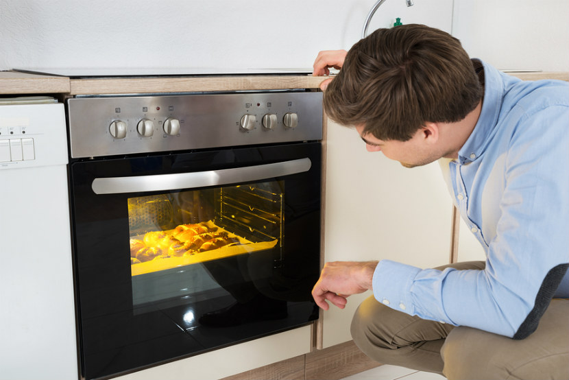 man looking into his oven