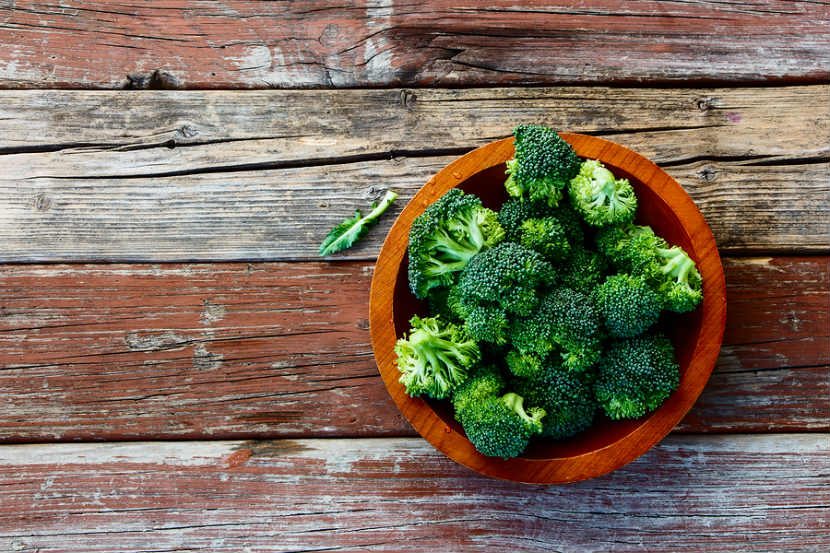bowl of broccoli on a wooden background