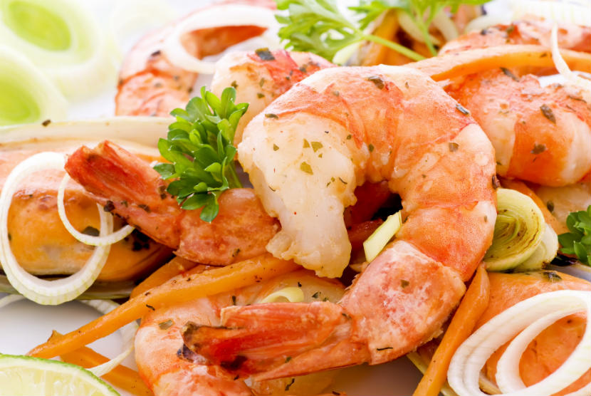 Pieces of cooked shrimp with onion, carrot and herbs