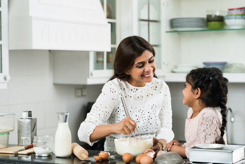 a woman and her daughter baking in the kitchen