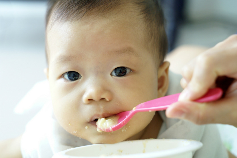 baby being fed solid food