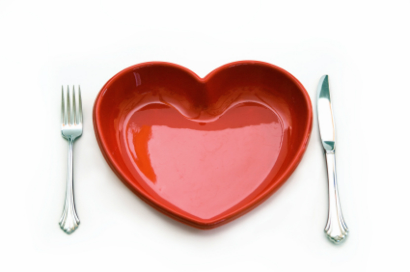 Knife and fork alongside a plate in the shape of a red heard