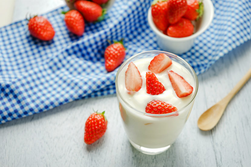 Contenant de yogourt avec des fraises fraîches