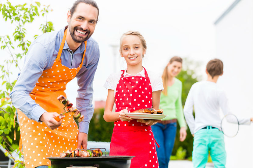 : famille faisant griller de la viande et des légumes sur le barbecue