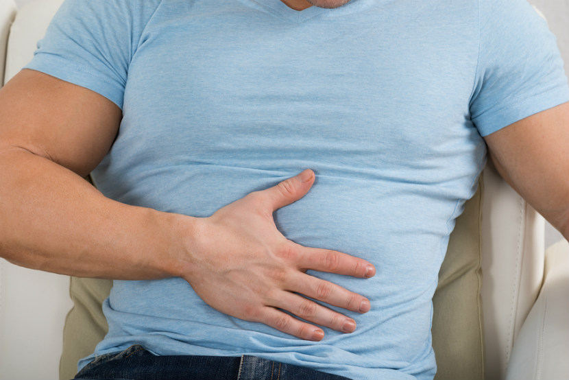 man holding stomach in discomfort