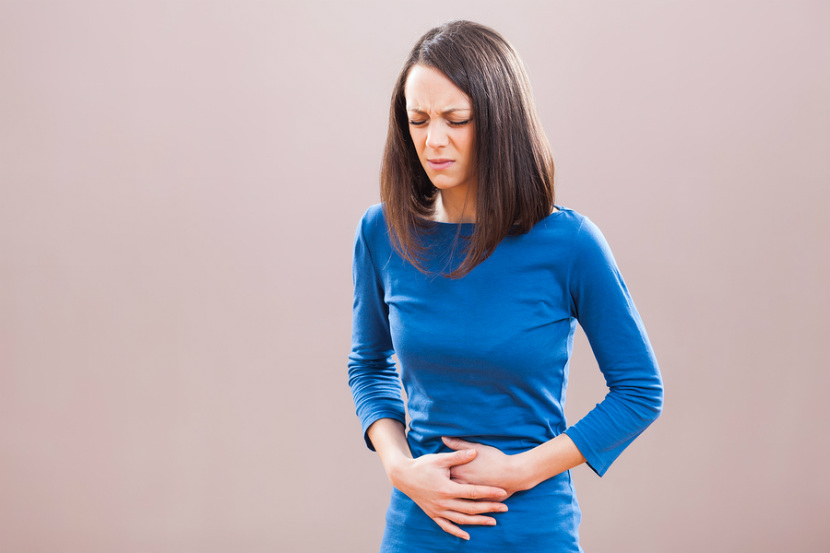 woman holding stomach in discomfort