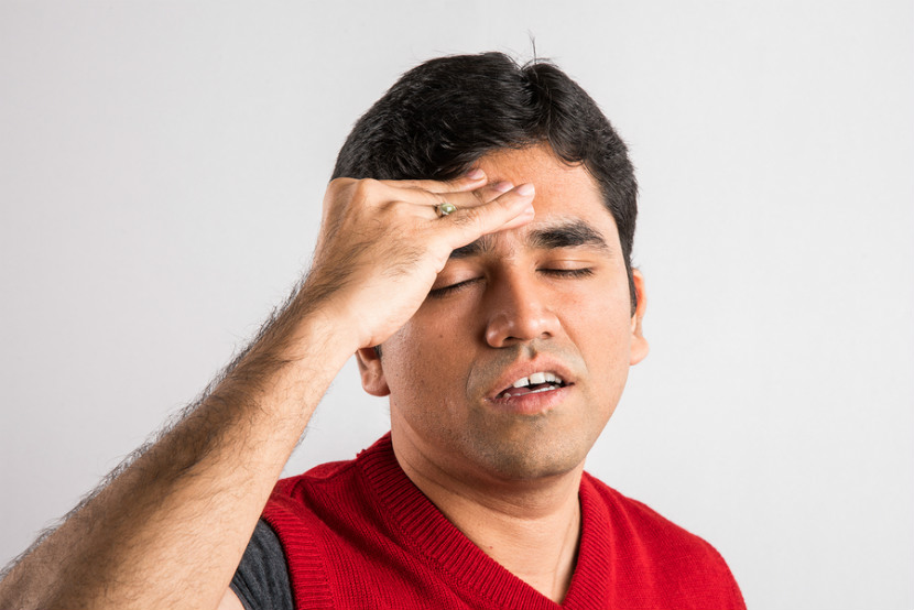 person holding their head due to a migraine or headache