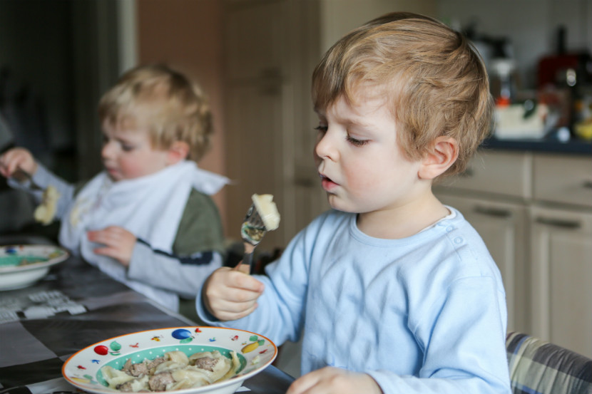 toddler eating dinner at the table