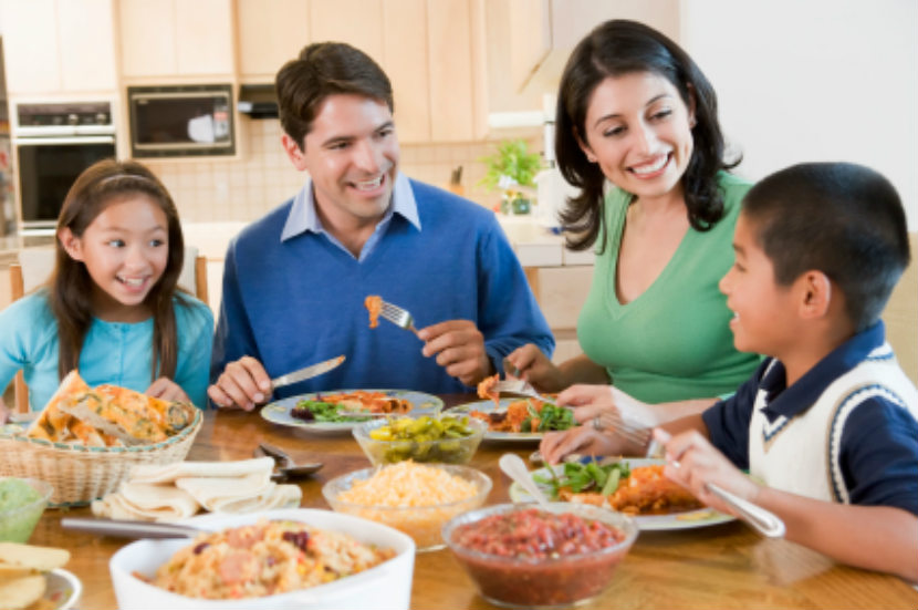 Famille souriante en train de prendre un souper nutritif et de parler
