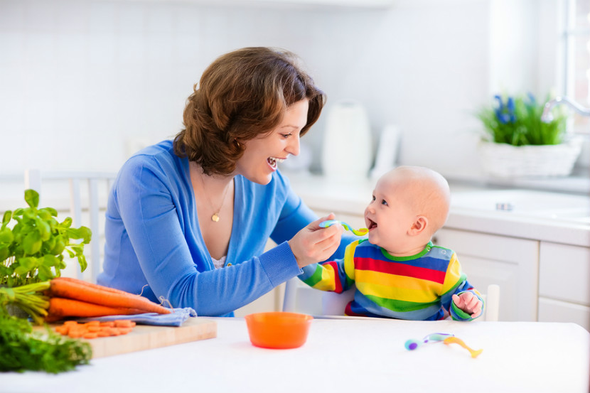 mother feeding her baby solid food