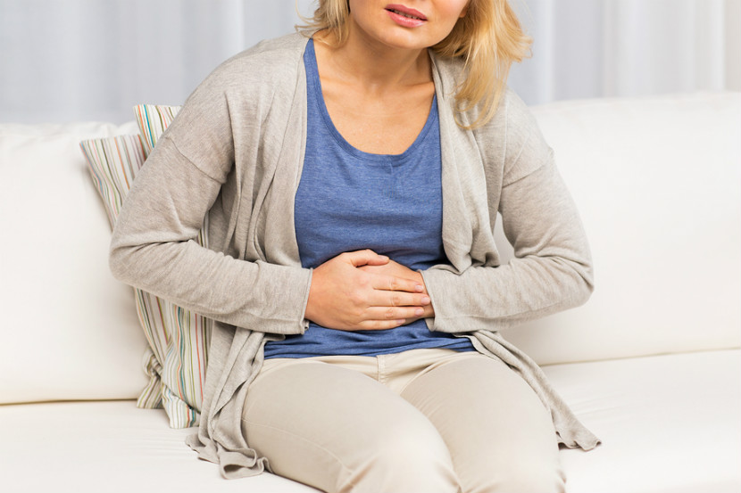 Woman holding stomach in discomfort and pain