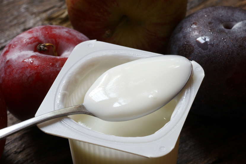 Yogourt probiotique avec une cuillère dedans et une pomme
