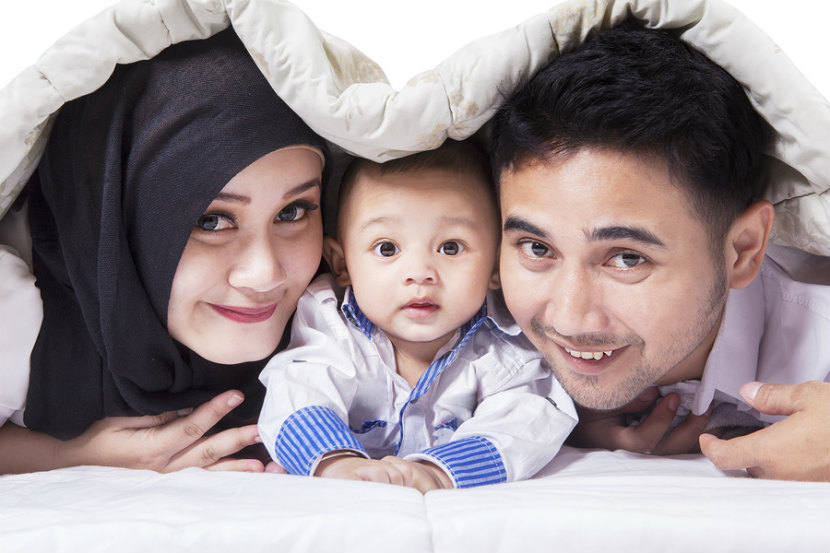 parents and their child playing under a blanket learning how to raise a child with healthy eating habits