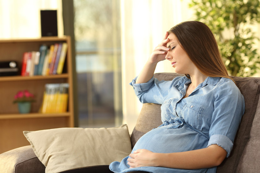 pregnant woman holding her stomach with nausea