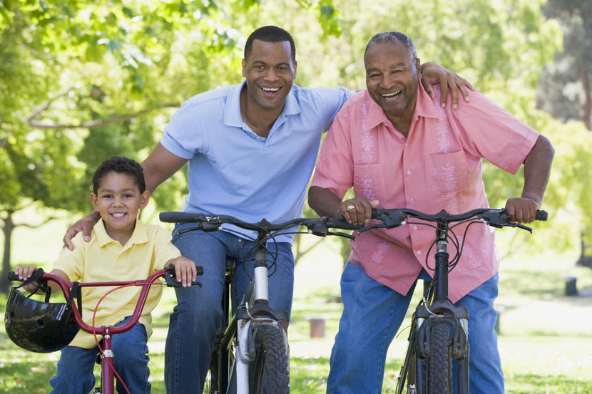 child, father and grandfather riding bicycles and smiling