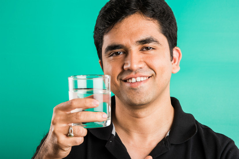 Homme buvant un verre d’eau pour prévenir les calculs rénaux