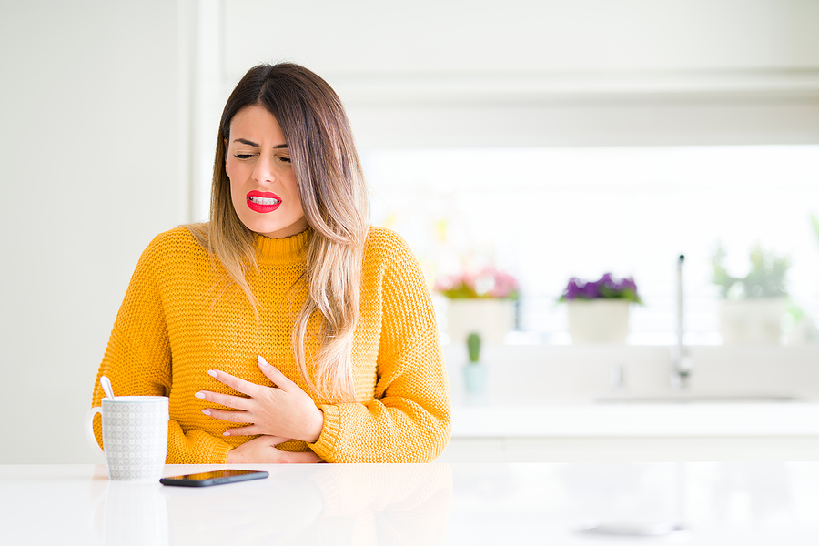 woman holding stomach in discomfort