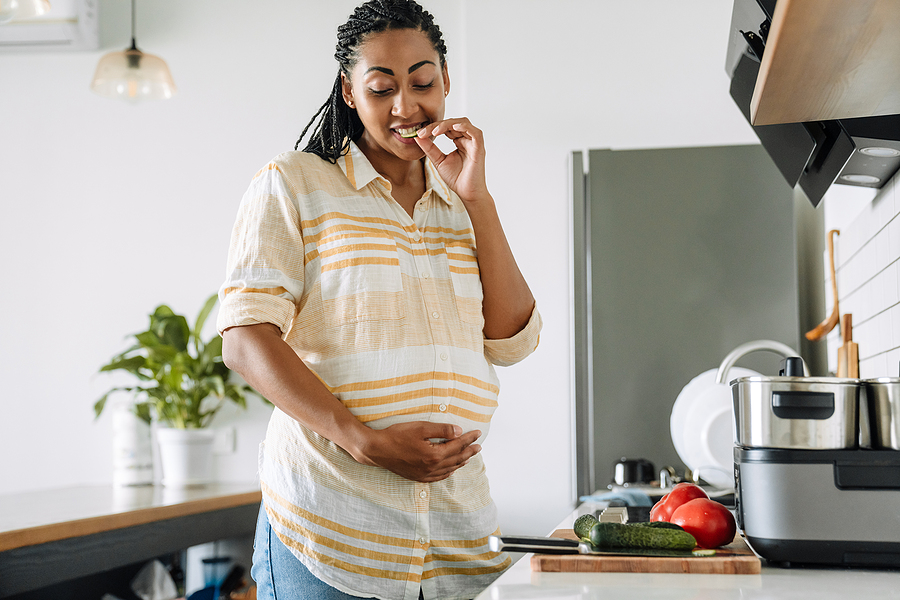 pregnant person eating healthy in kitchen