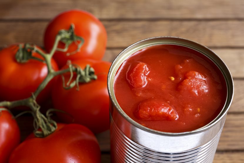 can of tomatoes next to fresh tomatoes